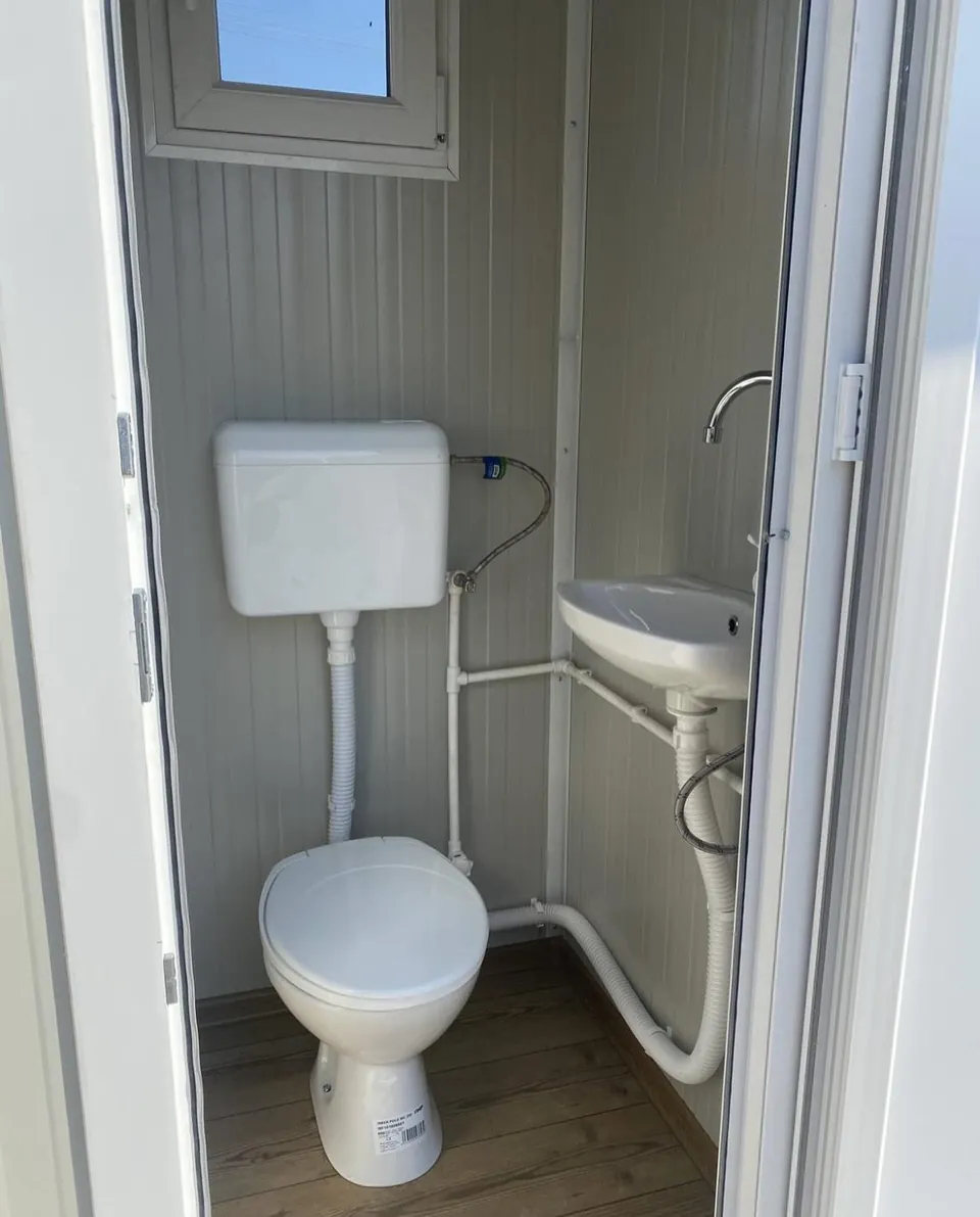 White portable restroom interior with toilet and sink